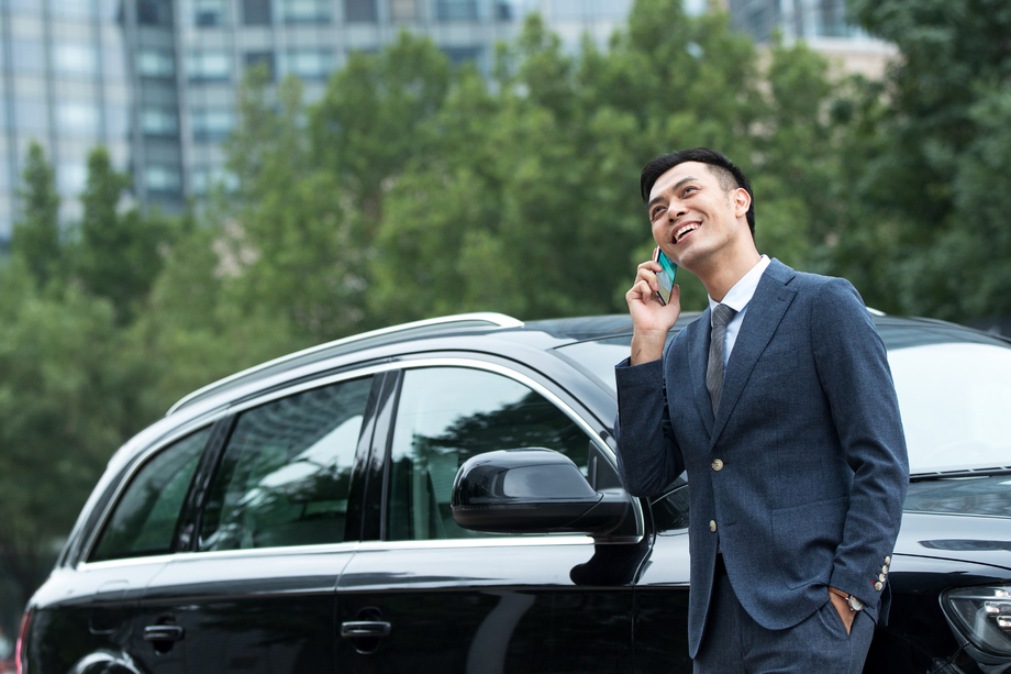 商务男士靠在汽车上打电话 商务男士靠在汽车上打电话