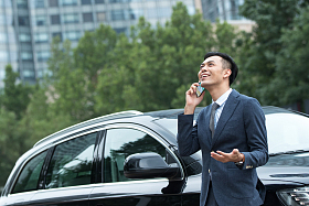 商务男士靠在汽车上打电话图片